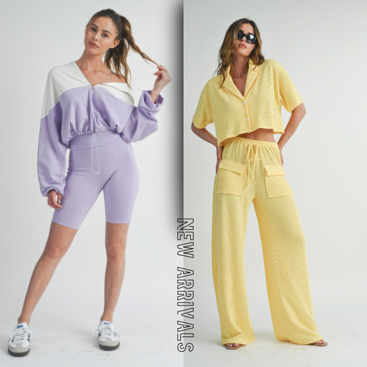 Two women modeling spring new arrivals – one wearing a lavender and white color-block zip-up sweatshirt with matching biker shorts, the other in a yellow textured short-sleeve button-up top and wide-leg pants set